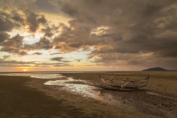 Altes hölzernes Matrosenboot strandet an einem Strand bei Sonnenuntergang — Stockfoto