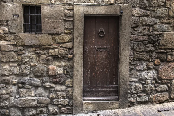 Porta medieval fechada em uma fachada de pedra parede de rocha — Fotografia de Stock