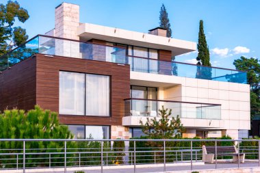 SOCHI, RUSSIA - 24 Kasım 2019: verandalı modern bir stil evi cephesi. Ahşap kalaslar ve teraslı cam bina, banklar ve yeşil bitkiler. Çağdaş gayrimenkul.
