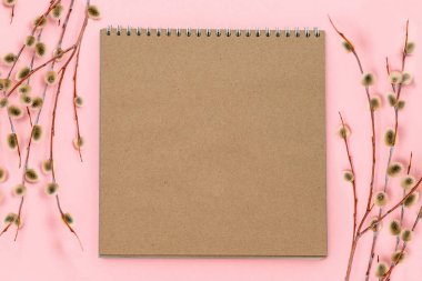 Bahar kompozisyonu. Kabarık söğüt dalları ve pembe arka planda kağıt boş not defterleri. Mutlu Paskalyalar, Palm Sunday. Düz konum, kopyalama alanı. Şenlikli menü, alışveriş listesi, tarif.