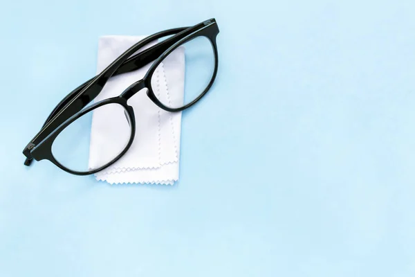 Gafas Borde Negro Paño Limpieza Sobre Fondo Azul Con Espacio — Foto de Stock