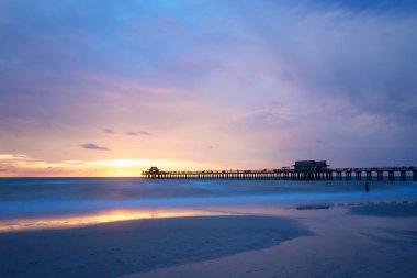 Mavi bir gökyüzü Napoli Pier, Florida, ABD ile bozulmamış ve pastoral plaj günbatımı