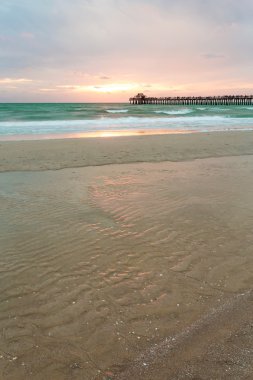 Mavi bir gökyüzü Napoli Pier, Florida, ABD ile bozulmamış ve pastoral plaj günbatımı