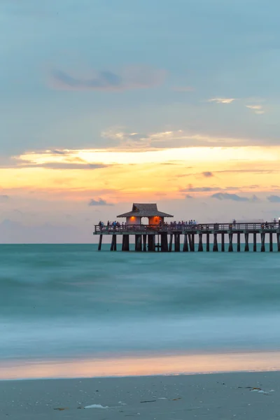 Pristine and idyllic beach sunset, with a blue sky in Naples Pier, Florida, USA