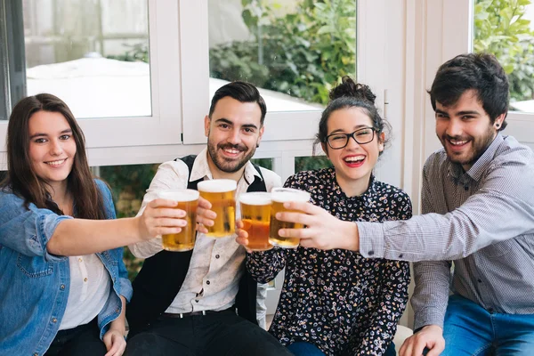 Unga vänner skålar med öl — Stockfoto