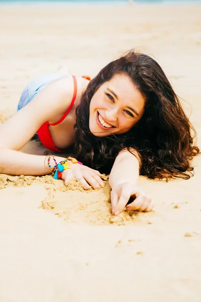 Jovem feliz deitada na praia — Fotografia de Stock