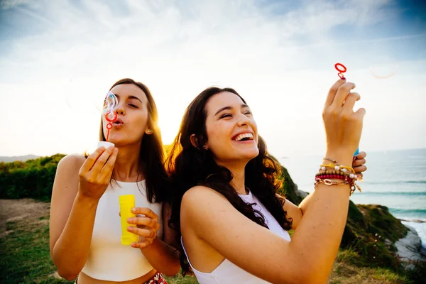 Funny young women blowing bubbles — Stock Photo, Image