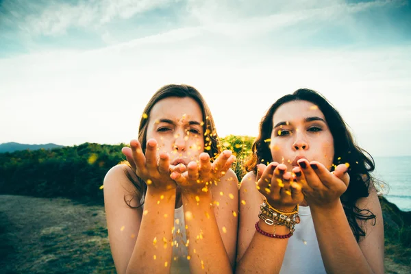 Lustige Mädchen wehen goldenen Glanz über eine Klippe — Stockfoto