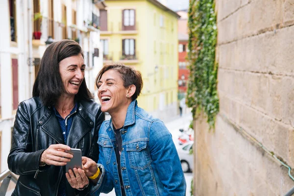 Grappig Middelbare Leeftijd Lesbisch Paar Lachen Iets Smartphone — Stockfoto