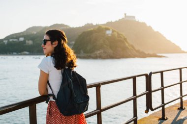 Genç turist kadın İspanya 'daki San Sebastian Körfezi manzarasının keyfini çıkarıyor.