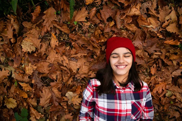 Szczęśliwa Nastolatka Dziewczyna Koszulą Kratę Czerwoną Wełnianą Czapką Leżącą Łóżku — Zdjęcie stockowe