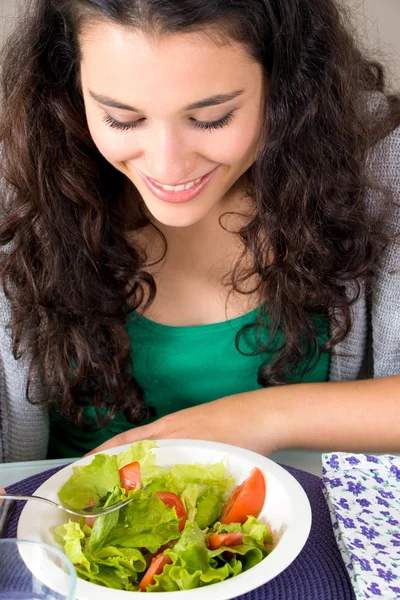 Здоровая и счастливая молодая женщина ест салат — стоковое фото