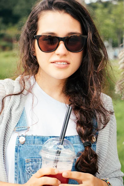 Hipster ragazza con occhiali da sole bere un frullato — Foto Stock