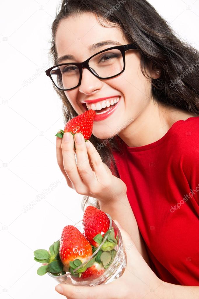 Happy woman eating strawberries