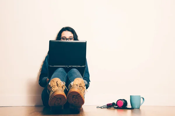 Nerd girl sitting on the floor with a laptop — Stock Photo, Image