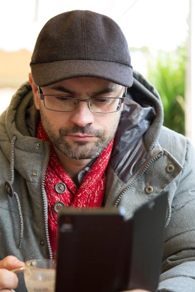 Man använder sin samrtphone samtidigt ha en kaffe — Stockfoto