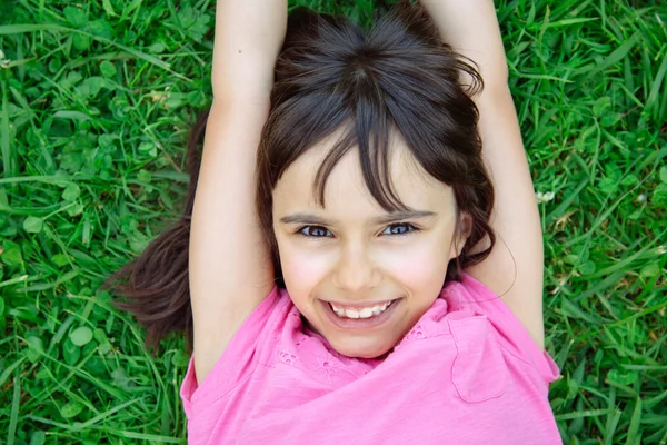 Belle fille couchée dans l'herbe — Photo