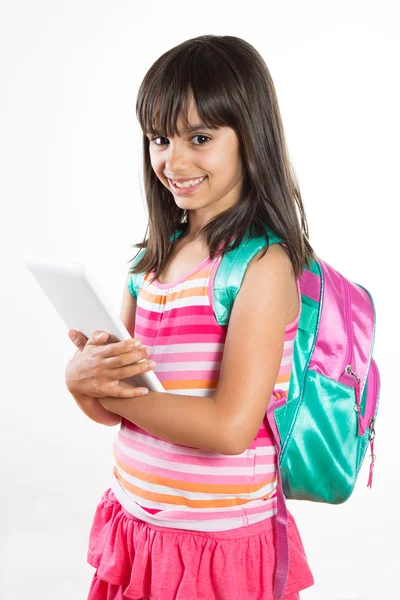 Menina da escola bonito e feliz segurando um tablet — Fotografia de Stock