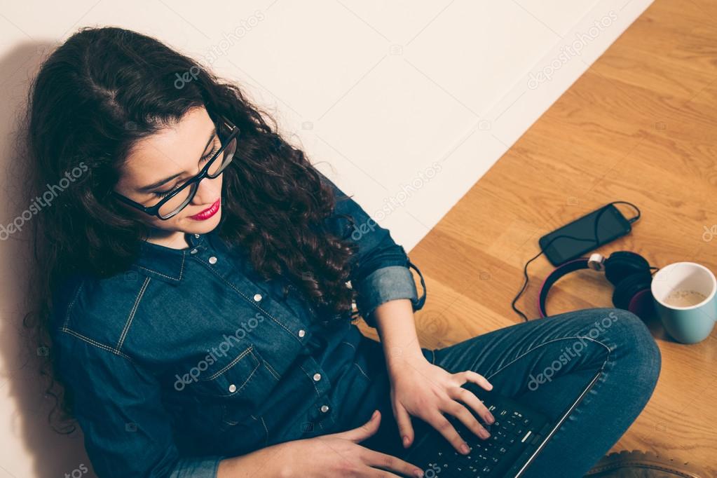 Hipster girl with laptop on the floor