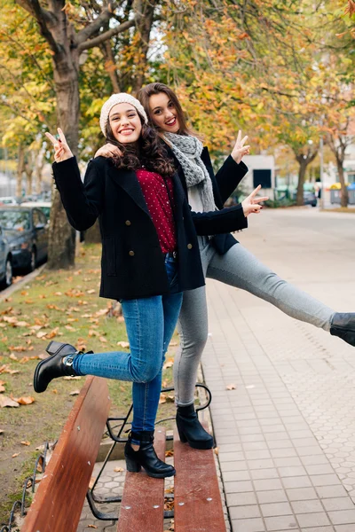 Lustige Freundinnen posieren mit Siegeszeichen — Stockfoto