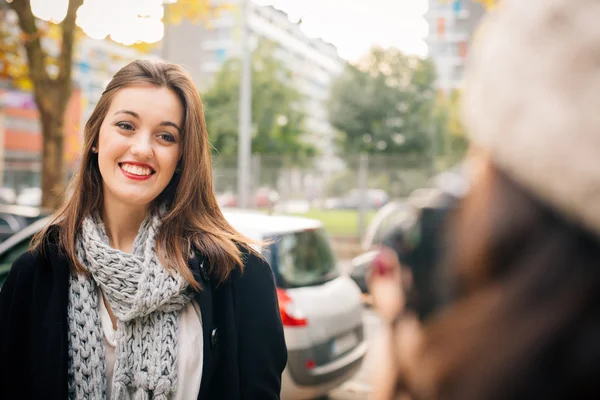 Glad tjej poserar för ett foto i staden — Stockfoto