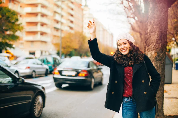 Joyeux jeune femme appelant un taxi dans la ville — Photo