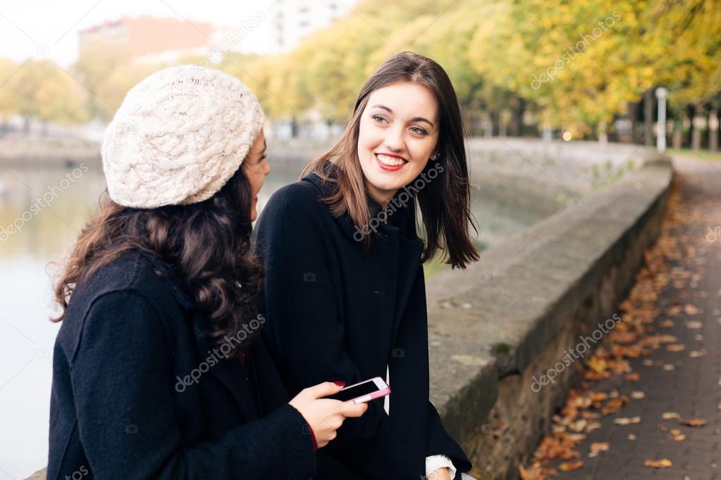 Young women friends talking outdoors