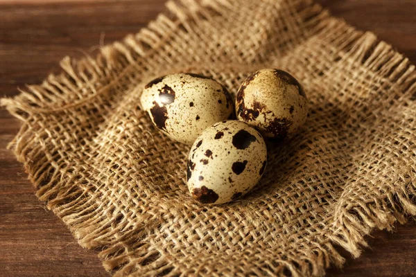 3つの有機的な斑点のあるウズラの卵が大まかなホームスンの背景にあります ロシア料理だ 閉めろ 健康的な製品と適切な栄養 — ストック写真