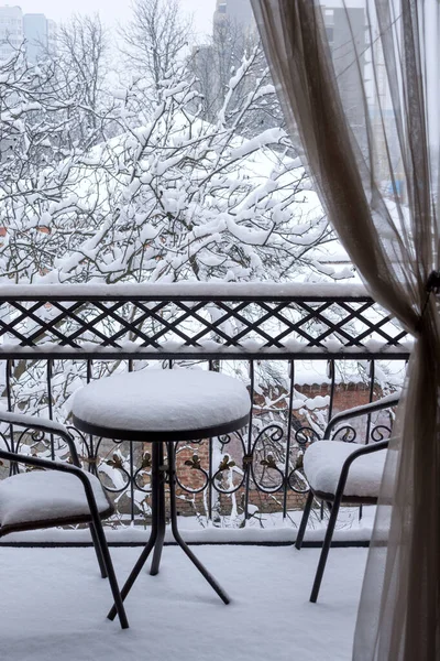The first white fluffy snow on the table and chairs on the wrought-iron balcony. Fabulous winter.