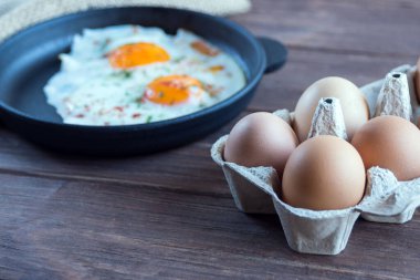 Karton tepside tavuk yumurtası, arka planda çırpılmış yumurta ve tepside yumurta.. 
