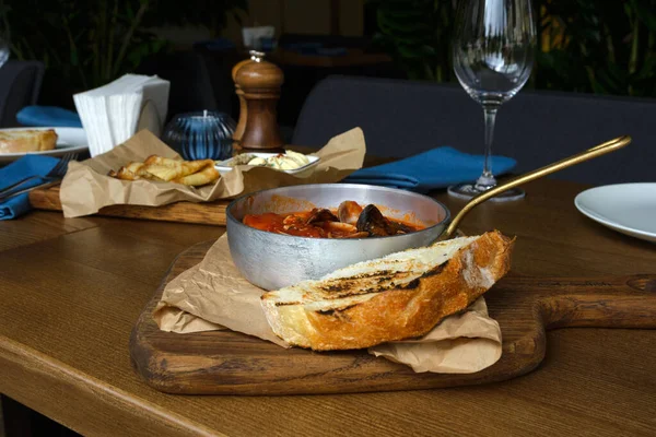 Delicious hearty lunch at a fish restaurant. Tuscan tomato soup with seafood Cacciucca. Cacciucco is a mixture of fish broth, red wine and tomato sauce.