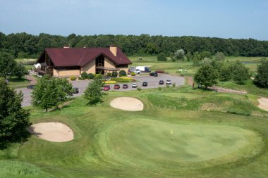 Ukrayna, Harkiv, Haziran 2021. Golf sahasında yeşil çimenler ve delikler. Güneşli bir yaz gününde golf sahası.