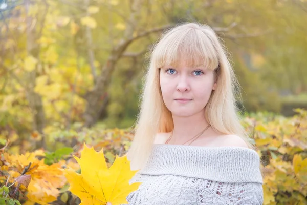 Blonde girl with yellow maple leaf — Stock Photo, Image