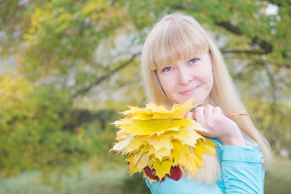 Blond meisje met gele esdoornblad — Stockfoto