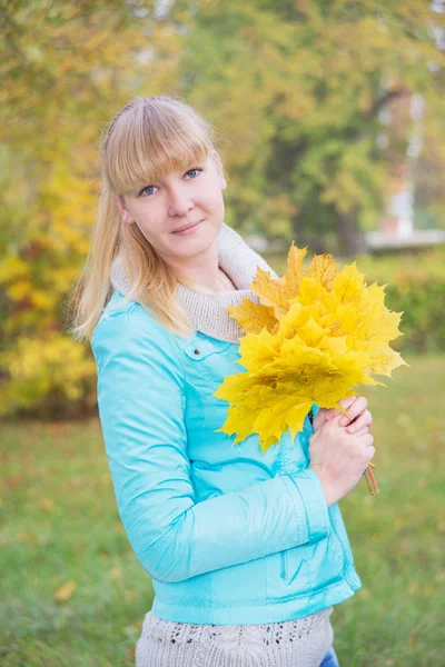 Blonde girl with yellow maple leaf — Stock Photo, Image