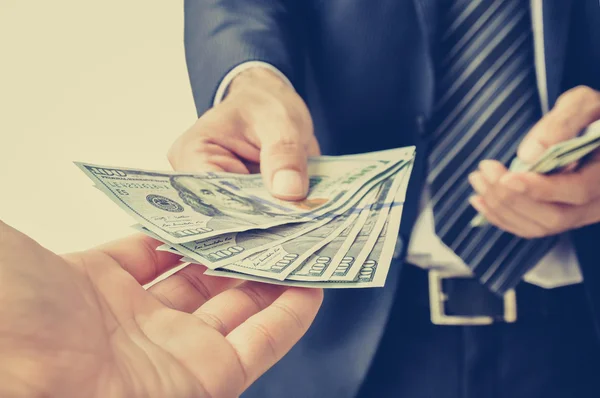 Hand receiving money, US dollar (USD) bills, from businessman — Stock Photo, Image