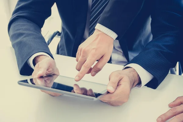 Två affärsmän använda Tablet PC: n med en hand vidrör skärmen — Stockfoto