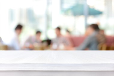 İnsanlar bulanıklık arka plan üzerinde beyaz ahşap masa