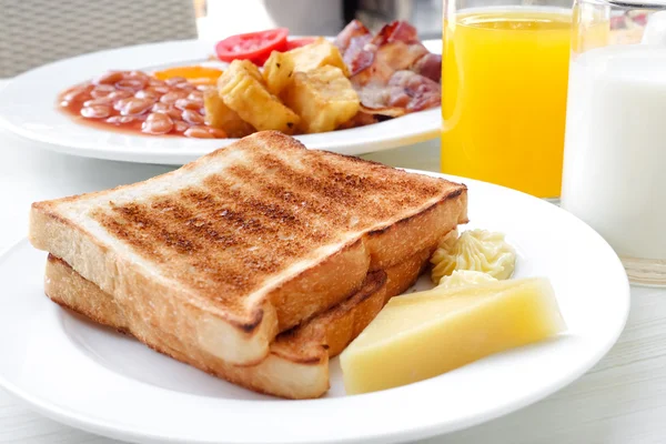 Pão torrado e manteiga com algumas bebidas na mesa no café da manhã conjunto — Fotografia de Stock