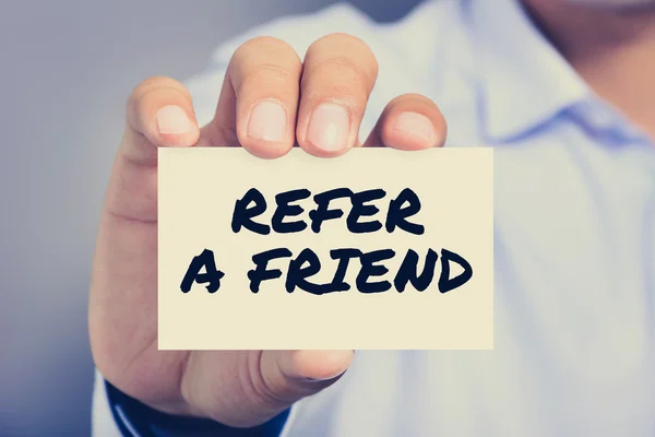 REFER A FRIEND, message on the card shown by a man — Stock Photo, Image