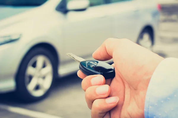 Um homem mão prestes a pressionar o botão da chave do carro de controle remoto — Fotografia de Stock