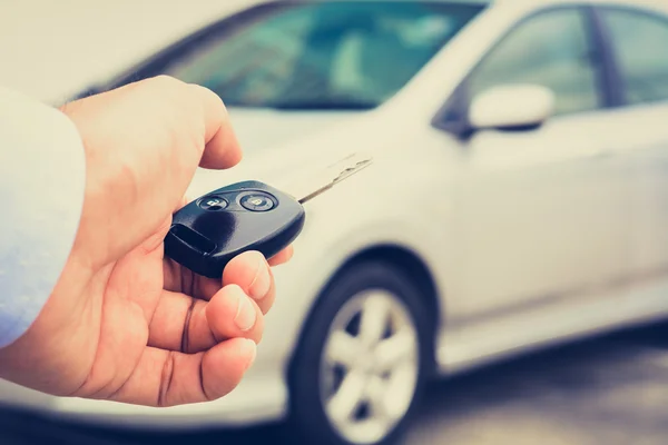 Una mano de hombre a punto de pulsar el botón de control remoto de la llave del coche —  Fotos de Stock