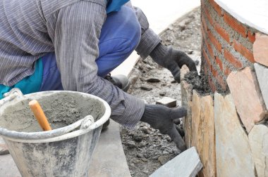 Mason işçi kaldırım taşları duvara harç ile yükleme