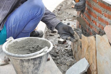 Mason işçi kaldırım taşları duvara harç ile yükleme