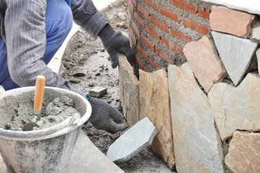 Kaldırım taşları tuğla duvar üzerinde yükleme Mason işçi