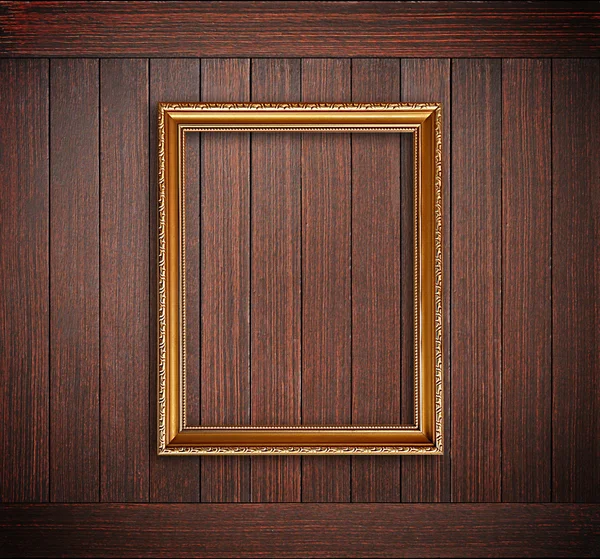 Golden picture frame on wooden wall — Stock Photo, Image