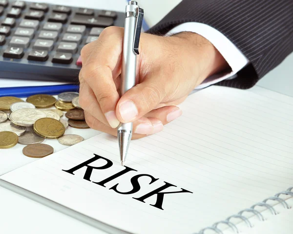 Hand with pointing to RISK word on the paper — Stock Photo, Image