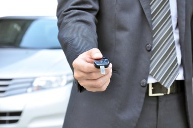 bir araba anahtarı veren işadamı