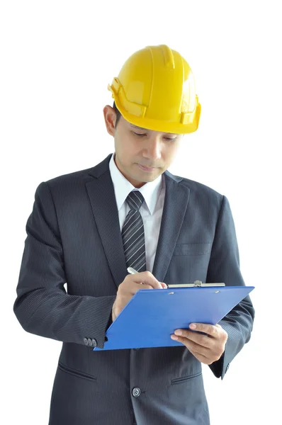 亚洲男子为建筑师或工程师穿西装 & 写作放在剪贴板上的安全帽 — 图库照片