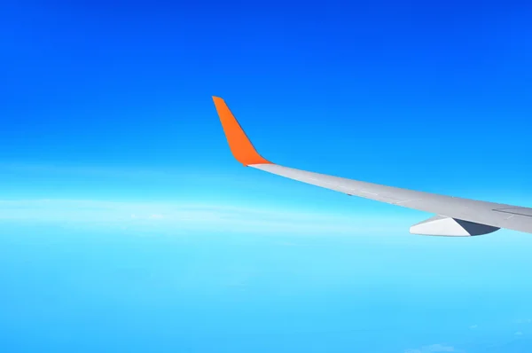 Asa do avião no fundo céu azul claro — Fotografia de Stock